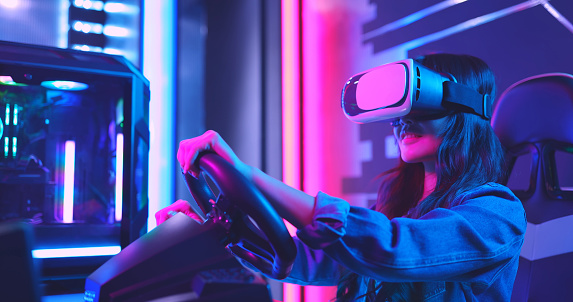 asian woman wears vr glasses and play car racing online video games