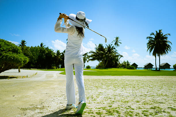 Woman Playing Golf A young woman is playing golf at seaside golf course exotic asian girls stock pictures, royalty-free photos & images