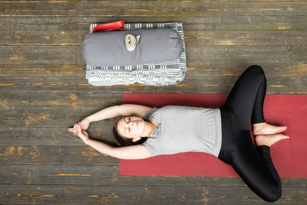 donna che pratica yoga in esercizio farfalla reclinata, supta baddha konasana - baddha konasana foto e immagini stock