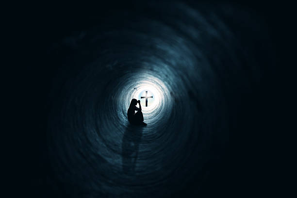 donna pregare in tunnel cristianesimo fede concetto - sinner foto e immagini stock