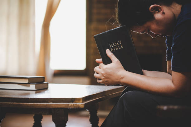 Woman praying on holy bible in the morning. stock photo