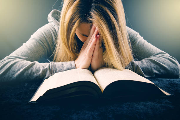 Woman Praying Over Bible stock photo