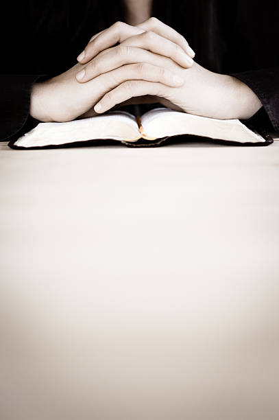 Woman praying with her hands on the Bible. stock photo