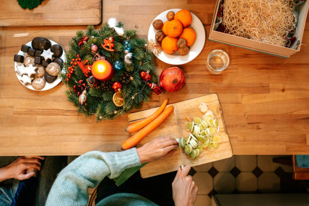Woman preparing vegetarian christmas meal on kitchen table stock photo
