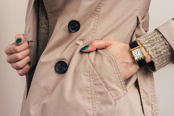 woman put her hand in coat pocket - woman horloge stockfoto's en -beelden