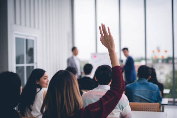 Woman raised up hands and arms  in seminar class room to agree with speaker at conference seminar meeting room Woman raised up hands and arms  in seminar class room to agree with speaker at conference seminar meeting room democracy photos stock pictures, royalty-free photos & images