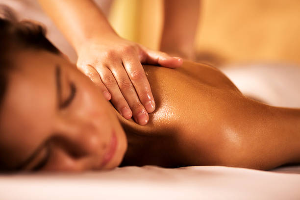 Woman receiving back massage. Young woman in the spa receiving back massage. Focus is on human hands. massage therapist stock pictures, royalty-free photos & images