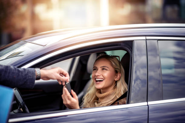 Woman receiving car key stock photo