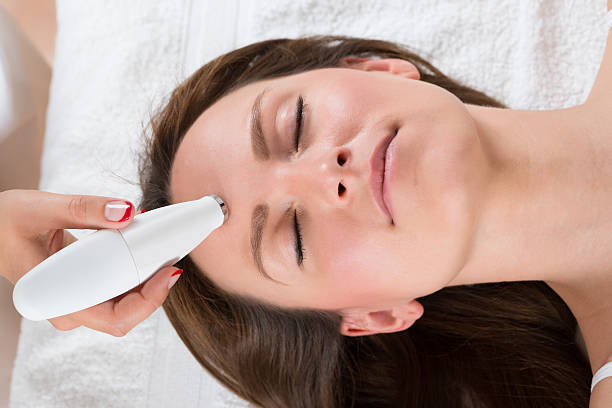Young Woman Receiving Microdermabrasion Therapy In Beauty Clinic