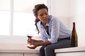 istock Woman relaxing after work by drinking wine in the kitchen. 828521774
