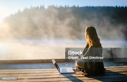 istock Woman Relaxing In Nature And Using Technology 1305227027