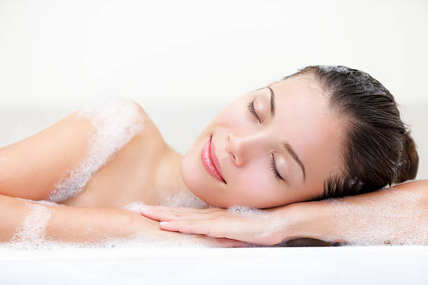A woman relaxing in the bathtub stock photo