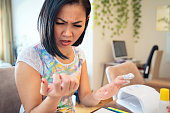 istock Woman removing nail polish with foil, damaging nails 1186964614