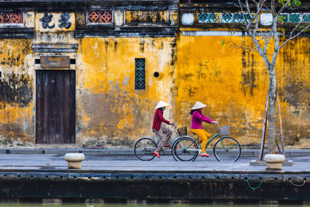Woman ride bicycle in Hoi An stock photo