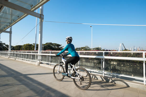 Woman riding bike at city on sunny day stock photo