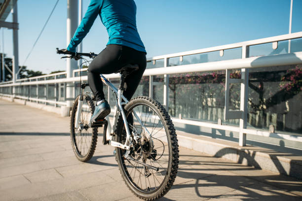 Woman riding bike at city on sunny day stock photo