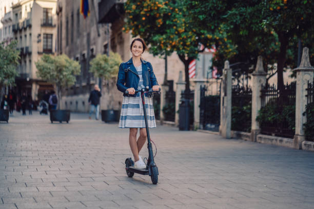 vrouw rijden motor scooter op plaza de la virgen in valencia - elektrische step stockfoto's en -beelden