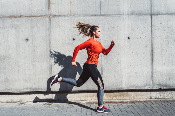 Woman running outdoors in the city stock photo