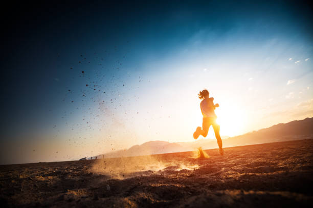 Woman runs on the desert Woman runs on the desert with lots of dust cross country running stock pictures, royalty-free photos & images