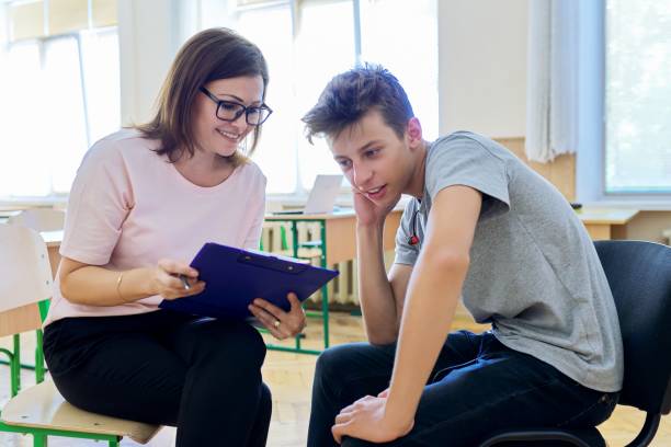 Woman school psychologist talking and helping student, male teenager Woman school psychologist talking and helping student, male teenager. Mental health of adolescents, psychology, social issues, professional help of counselor teenager stock pictures, royalty-free photos & images