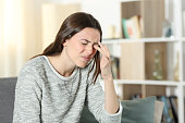 istock Woman scratching itchy eye at home 1297433295