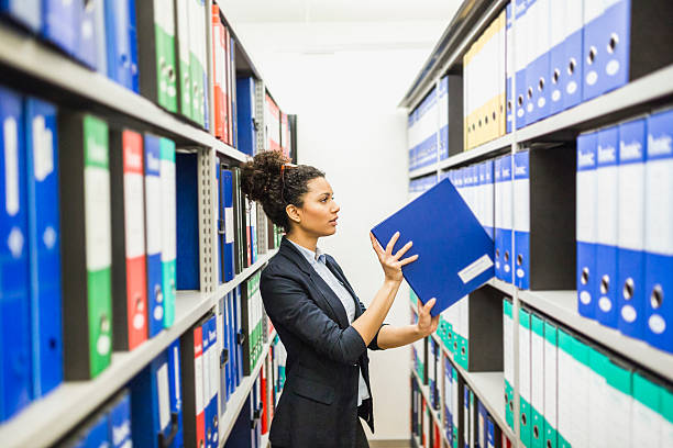 Woman searching for files in paper archive Secretary working in paper archive bureaucracy stock pictures, royalty-free photos & images