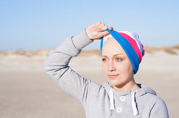 mulher mostrando bald head-efeitos secundários da quimioterapia - bald beach imagens e fotografias de stock