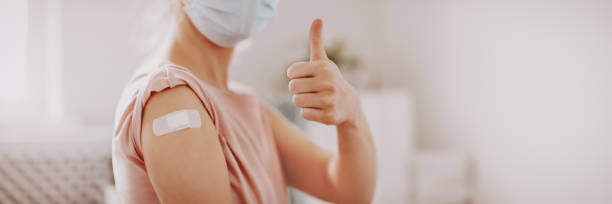Woman showing thumb up after inoculation against Covid 19. stock photo