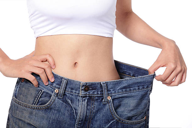 女性は減量を合わせてジーンズ - ダイエット ストックフォトと画像