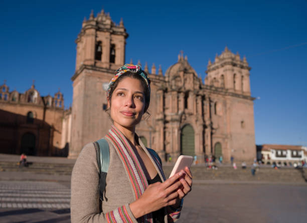 Woman sightseeing around Cusco while texting on her cell phone Portrait of a woman sightseeing around Cusco while texting on her cell phone - travel concepts peru woman stock pictures, royalty-free photos & images