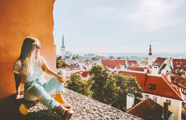 Woman sightseeing Tallinn city landmarks  vacations in Estonia travel lifestyle girl tourist relaxing at viewpoint Old Town aerial view architecture stock photo