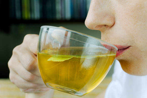 Woman sipping green tea from a large clear cup stock photo
