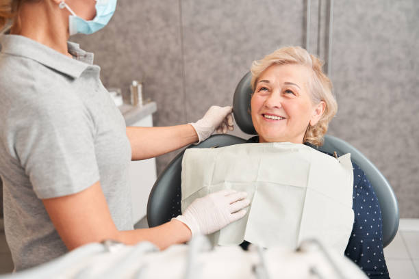 Woman sitting in dental chair and listening to dentist stock photo