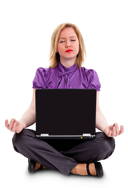 Woman sitting in lotus position with laptop stock photo