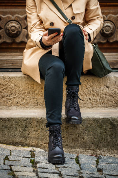 Woman sitting on stairs and using smart phone in city stock photo