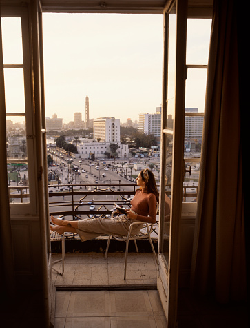 Young Caucasian woman sitting on the balcony and looking at view