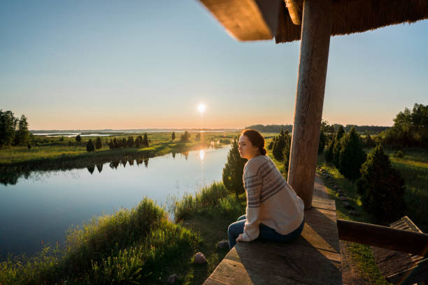 Woman sitting on wooden fence  on swamp in Estonia Young Caucasian woman  sitting on wooden fence  on swamp in Estonia baltic countries stock pictures, royalty-free photos & images