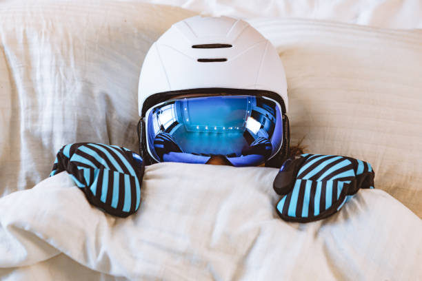 woman sleeping in bed in ski equipment stock photo
