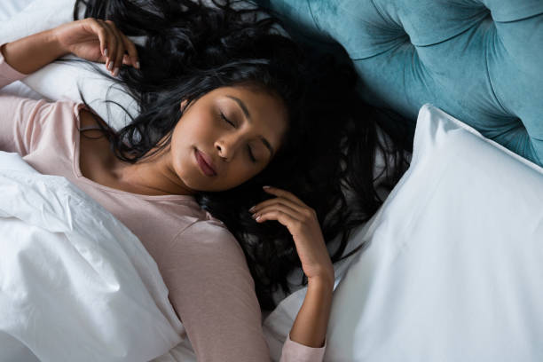 Woman sleeping on bed at home High angle view of young woman sleeping on bed at home sleep with long hair stock pictures, royalty-free photos & images
