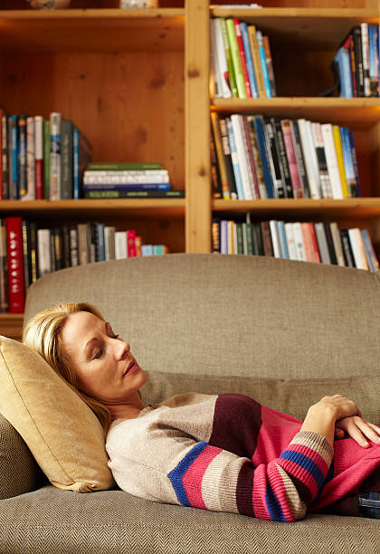 woman sleeping on sofa - nap middle age woman bildbanksfoton och bilder