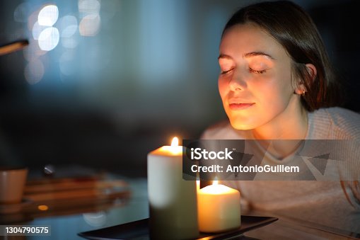 istock Woman smelling a lighted candle in the night 1304790575