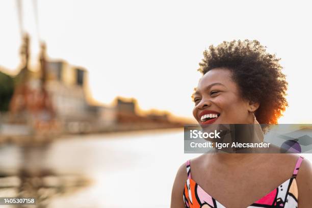 Woman smiling at sunset on the bay in the city