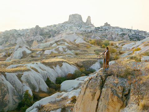 Young Caucasian woman  standing and looking at caves in  Cappadocia in Turkey