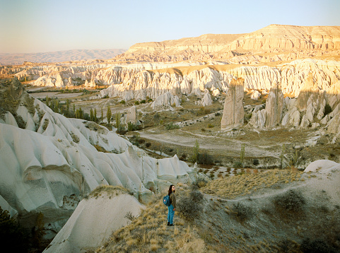 Young Caucasian woman  standing and looking at caves in  Cappadocia in Turkey