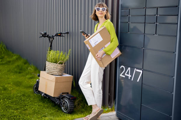 Woman standing with phone near automatic post terminal and scooter stock photo