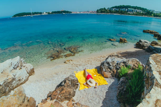 woman sunbathing at sea beach in sunny day stock photo