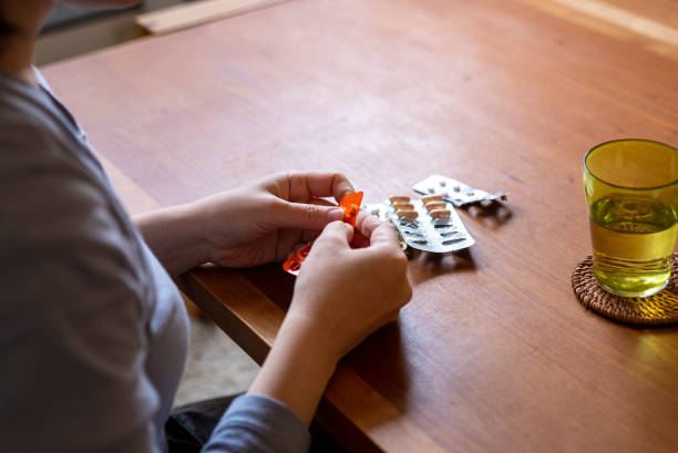 A woman taking medicine in her room at home. stock photo