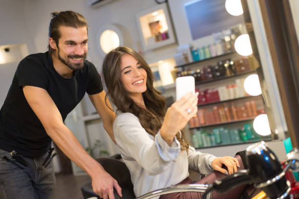 Woman taking selfie with her hairdresser stock photo