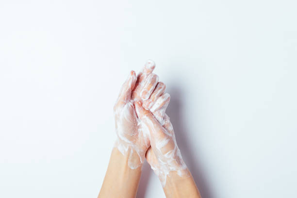Woman thoroughly washing her hands with soap stock photo