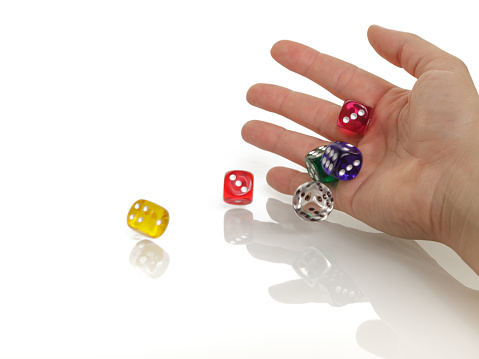 Woman throwing some colorful dices with her hands isolated on white background. Gambling, casino and business concept.